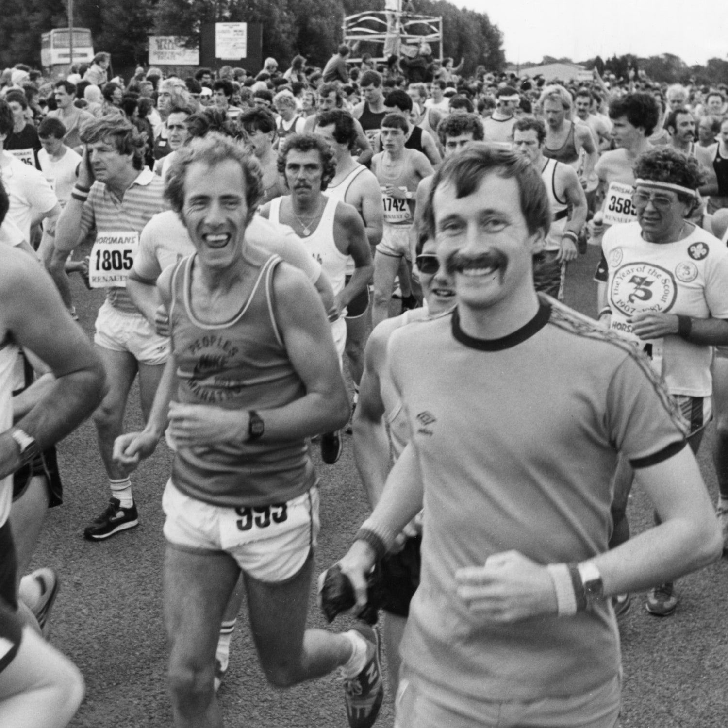 A large group of male runners begins the Mersey Marathon with big smiles on their faces