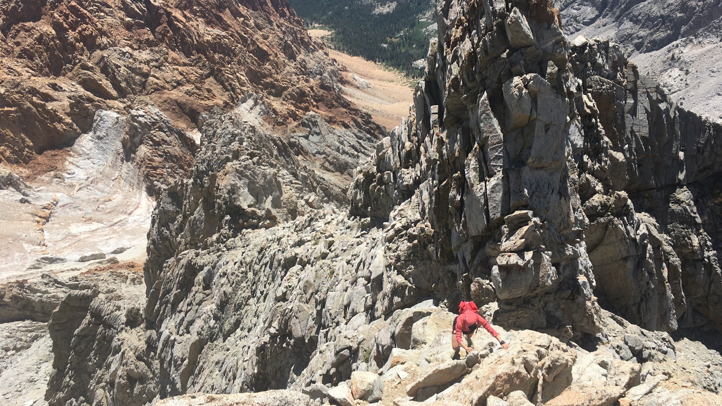 person climbing mountain rough terrain