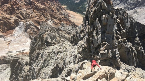 person climbing mountain rough terrain