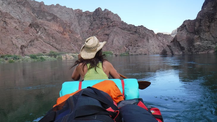 woman canoes in calm water in the Black Canyon, Nevada