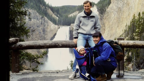 a mom, dad, and baby in front of a waterfall
