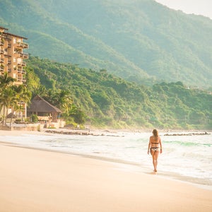 woman walking at the Punta Negra beach in Puerto Vallarta, Mexico
