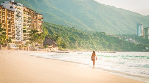 woman walking at the Punta Negra beach in Puerto Vallarta, Mexico