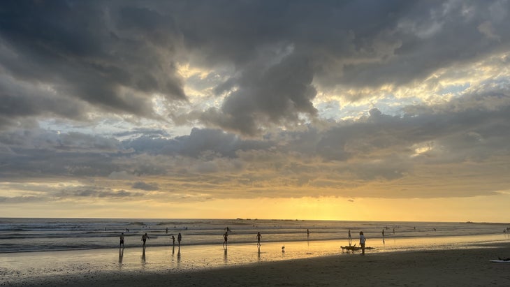 Playa Guiones Costa Rica, tourists on the beach, sunset