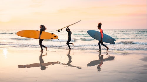 three Black surfers walking on beach