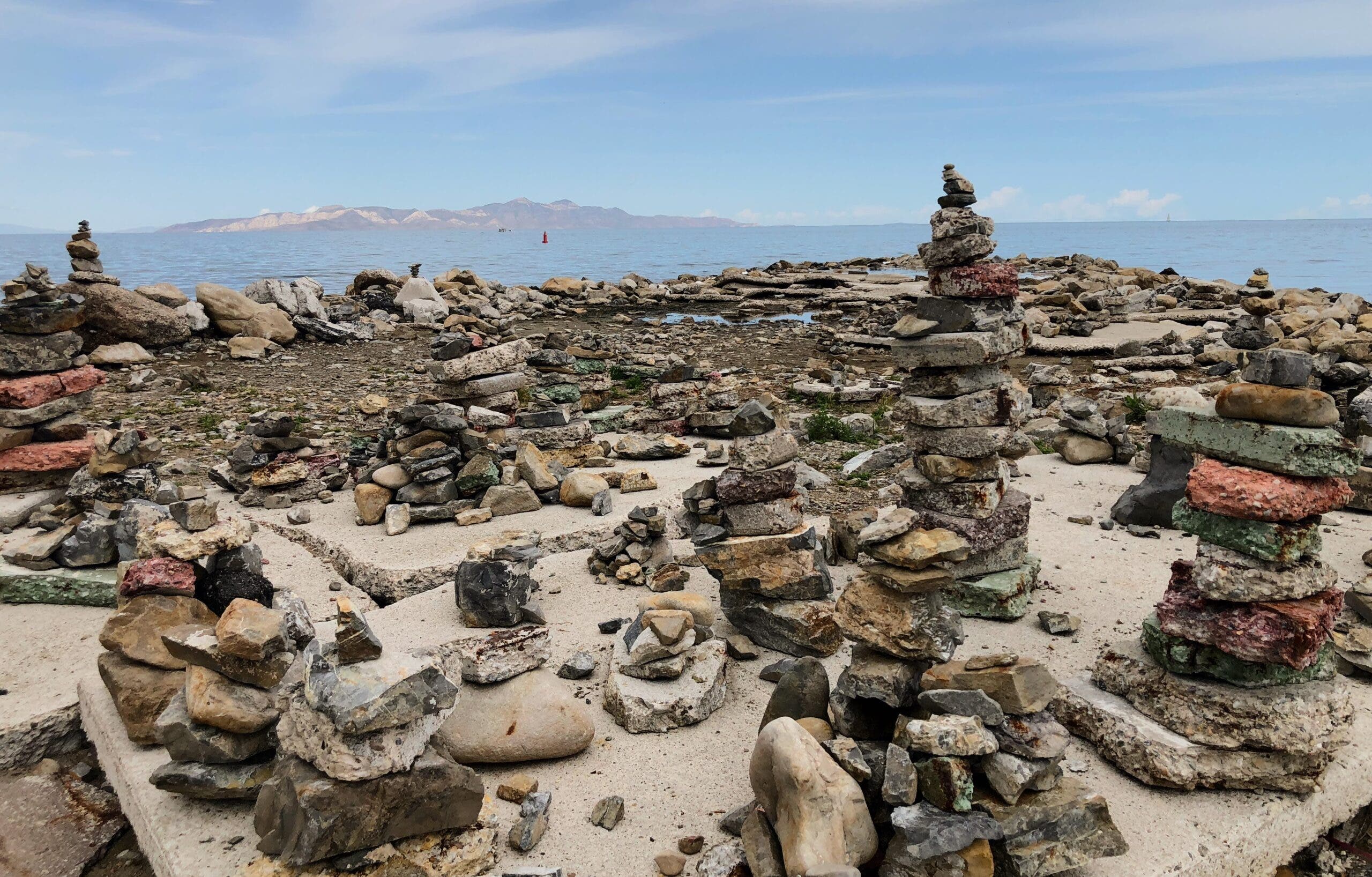 a collection of cairns by a lake