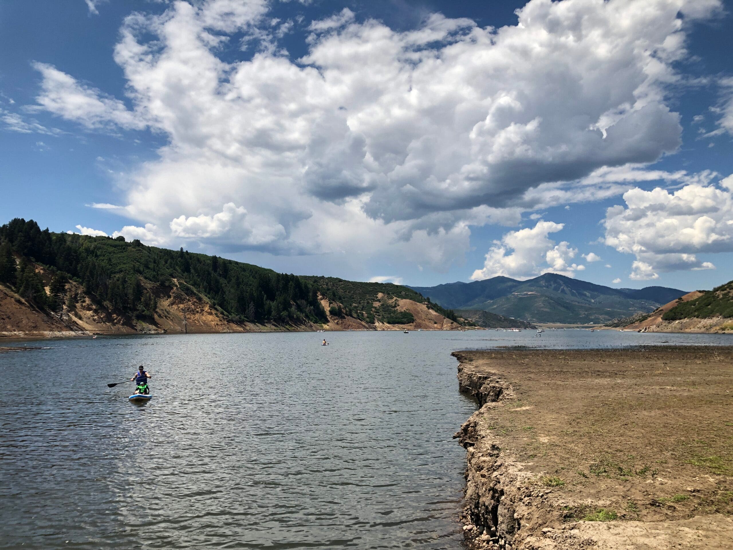 a stand up paddleboard on a reservoir in the mountains