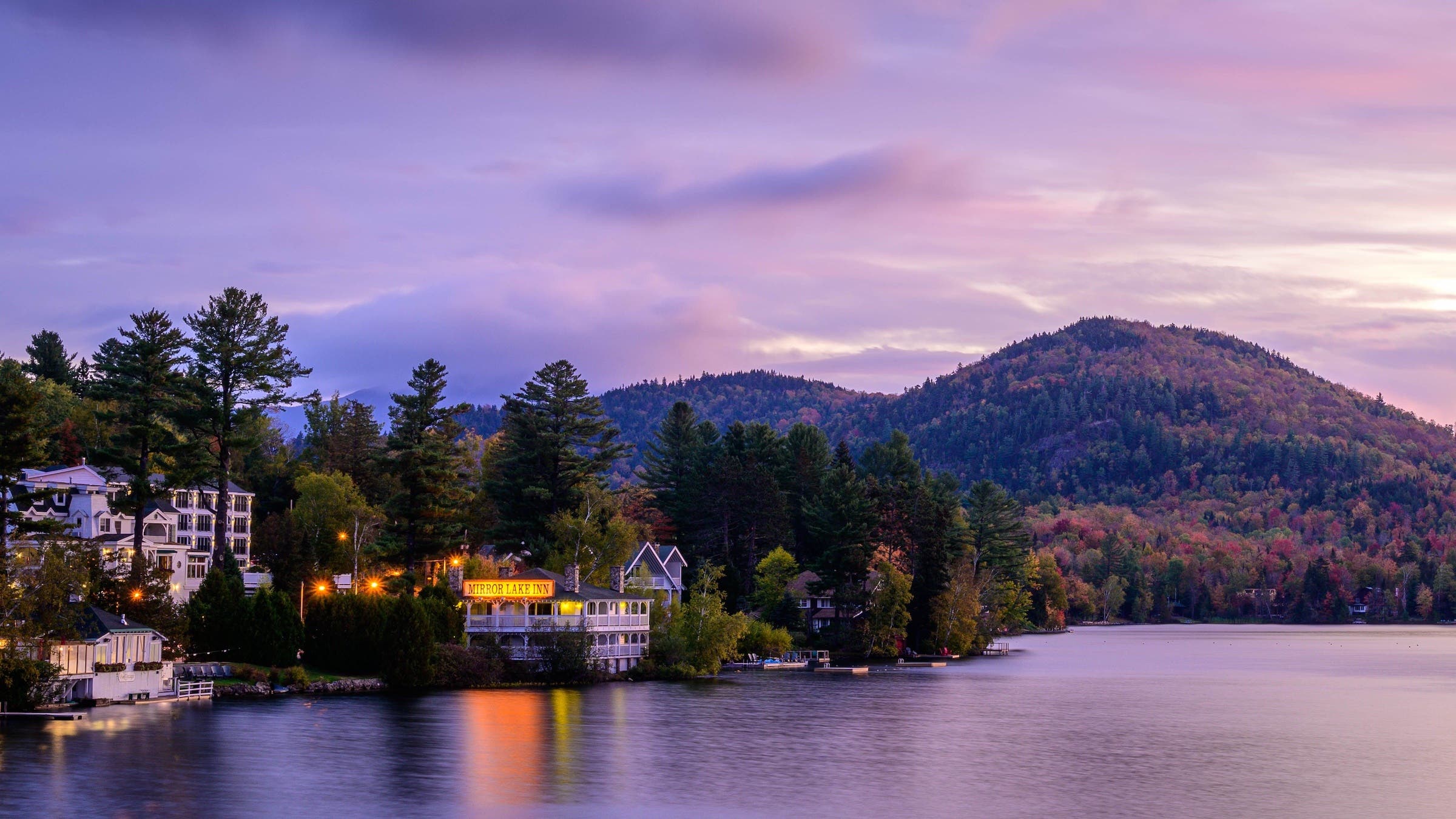 inn on lake at sunset with mountains in back