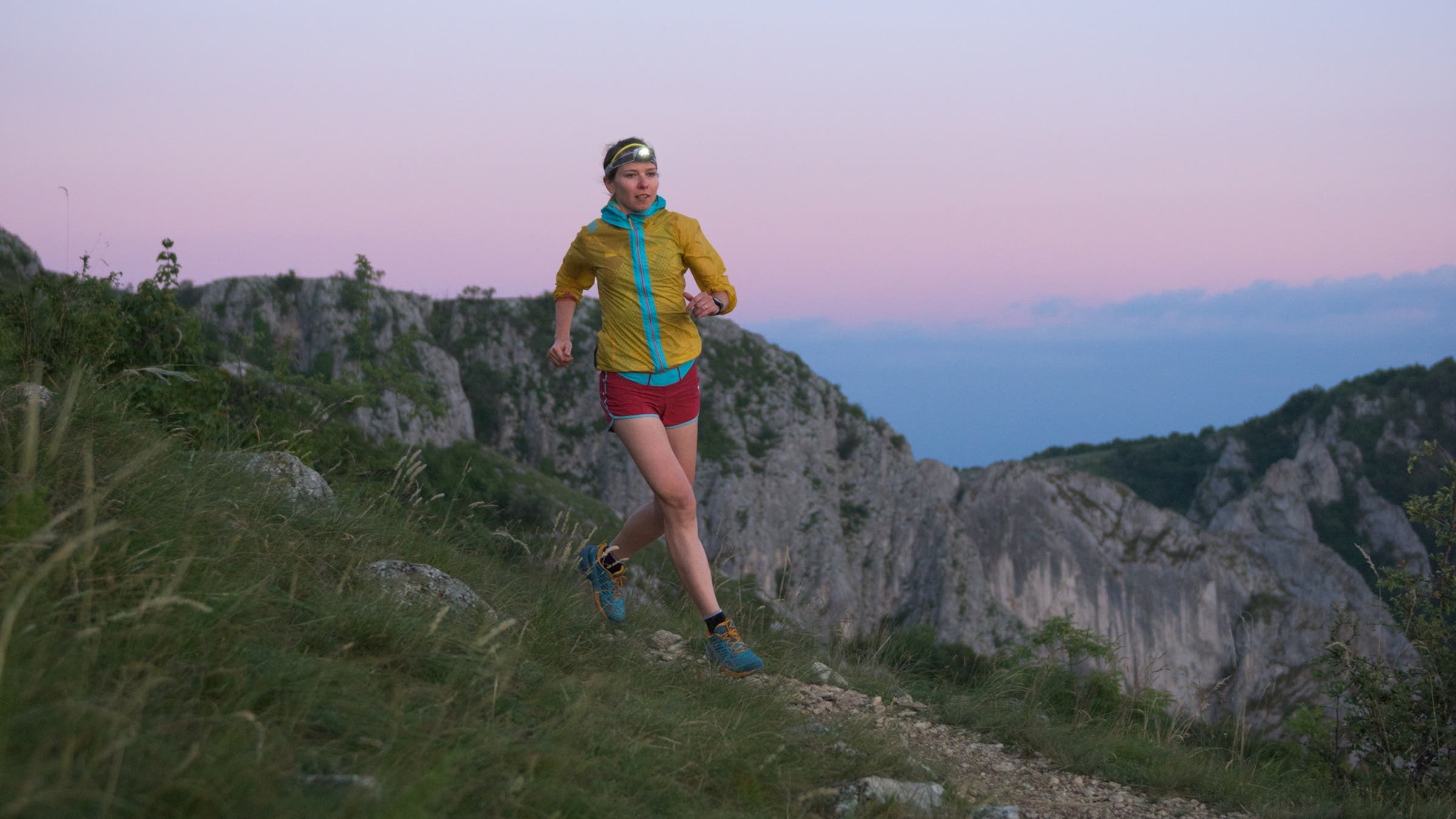 trail runner at sunrise with headlamp on