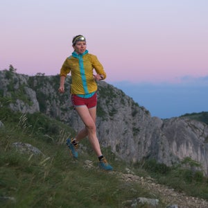 trail runner at sunrise with headlamp on