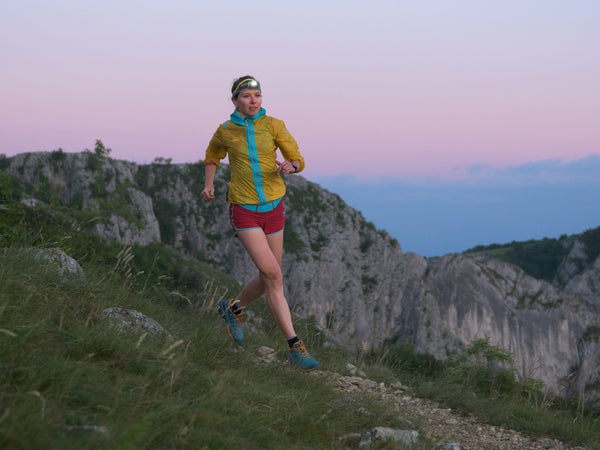 trail runner at sunrise with headlamp on