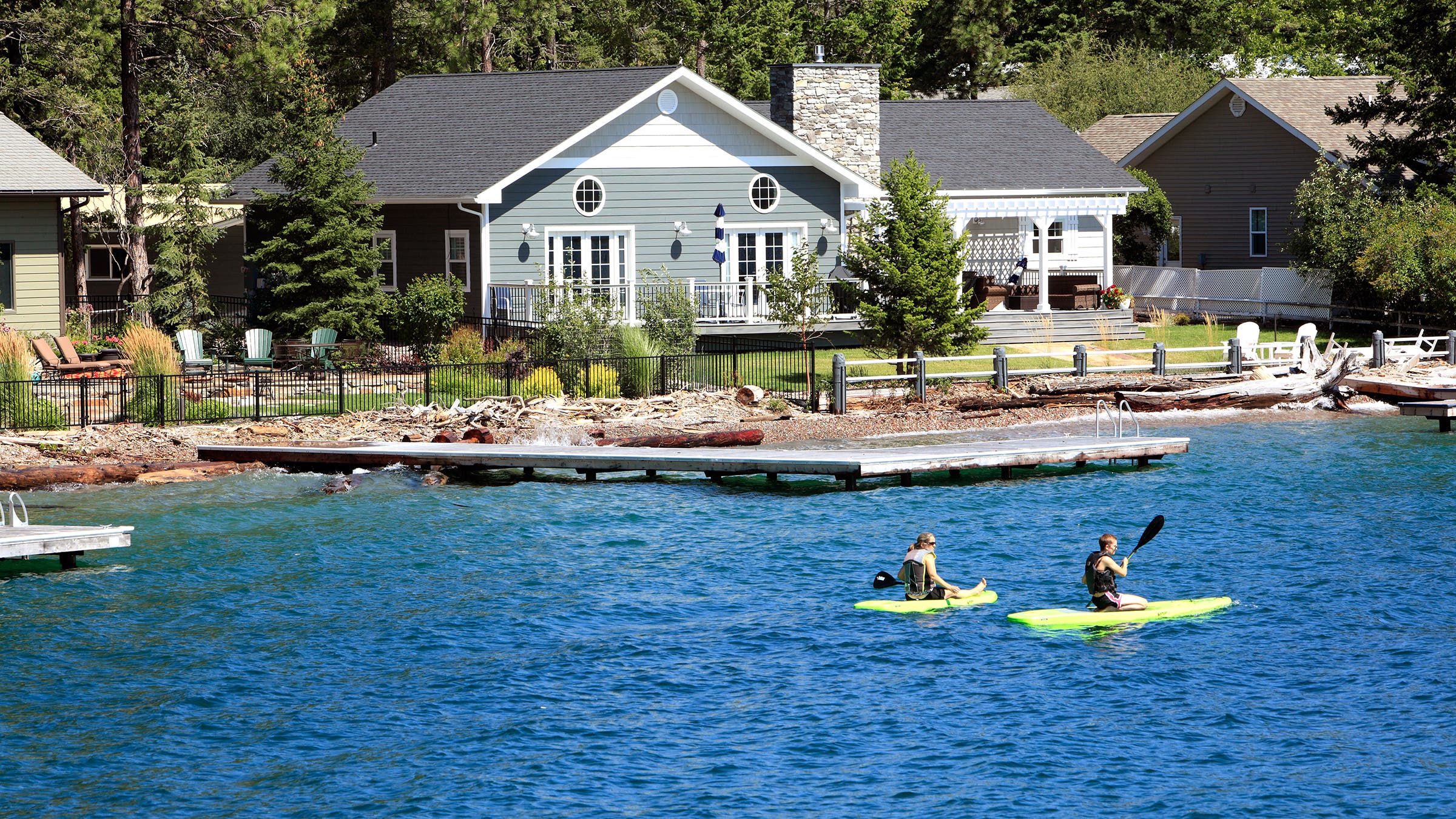 Two paddleboarders peruse Woods Bay, in Bigfork, Montana, on a sunny, summer day
