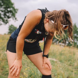 Young female athlete exhausted after running a marathon in the nature.