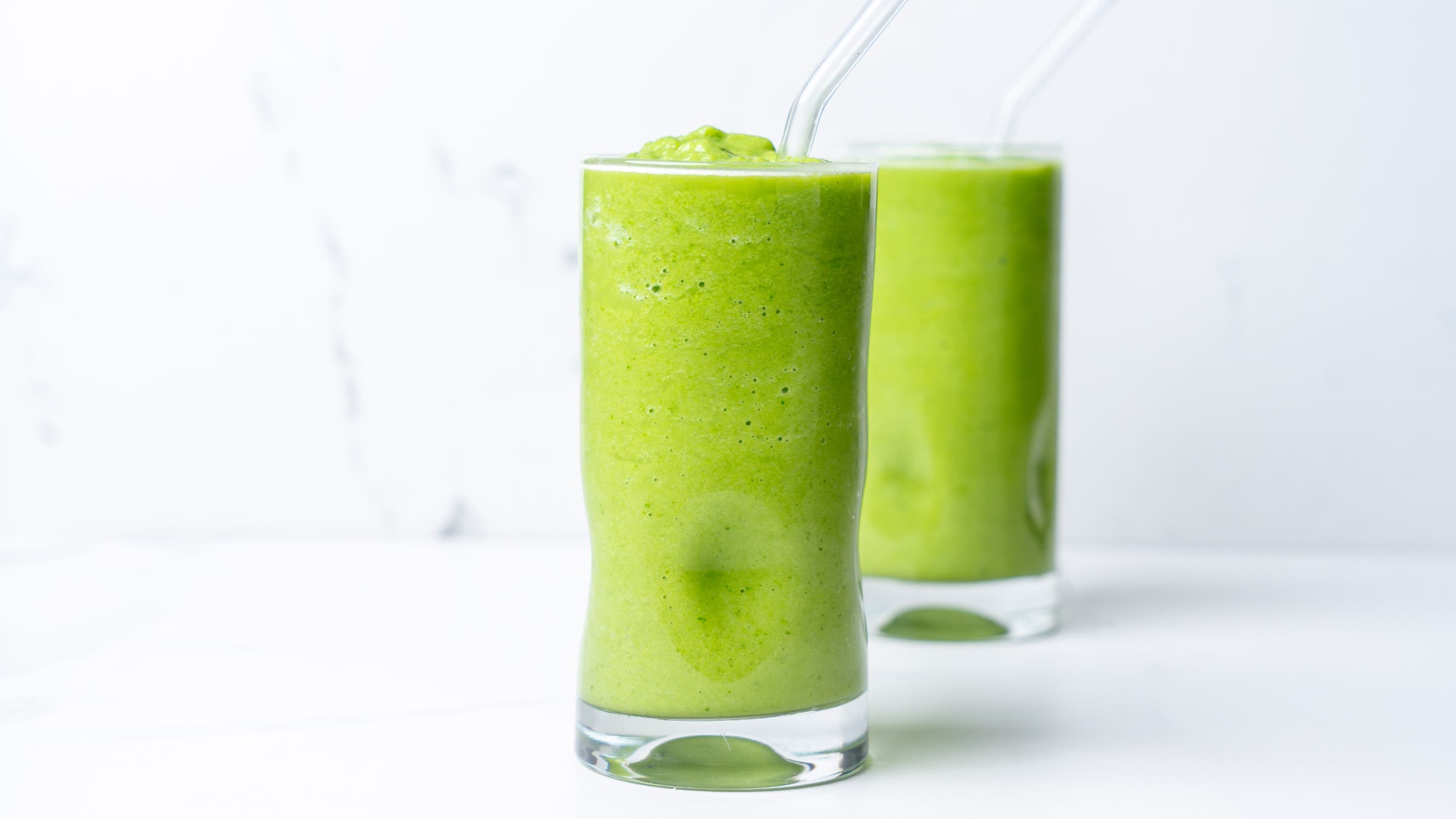 Green aloe vera smoothie recipe; two glasses filled to the brim