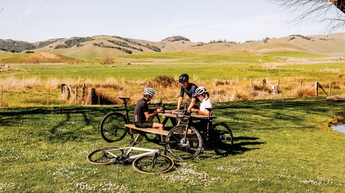 cyclists resting at a picnic table