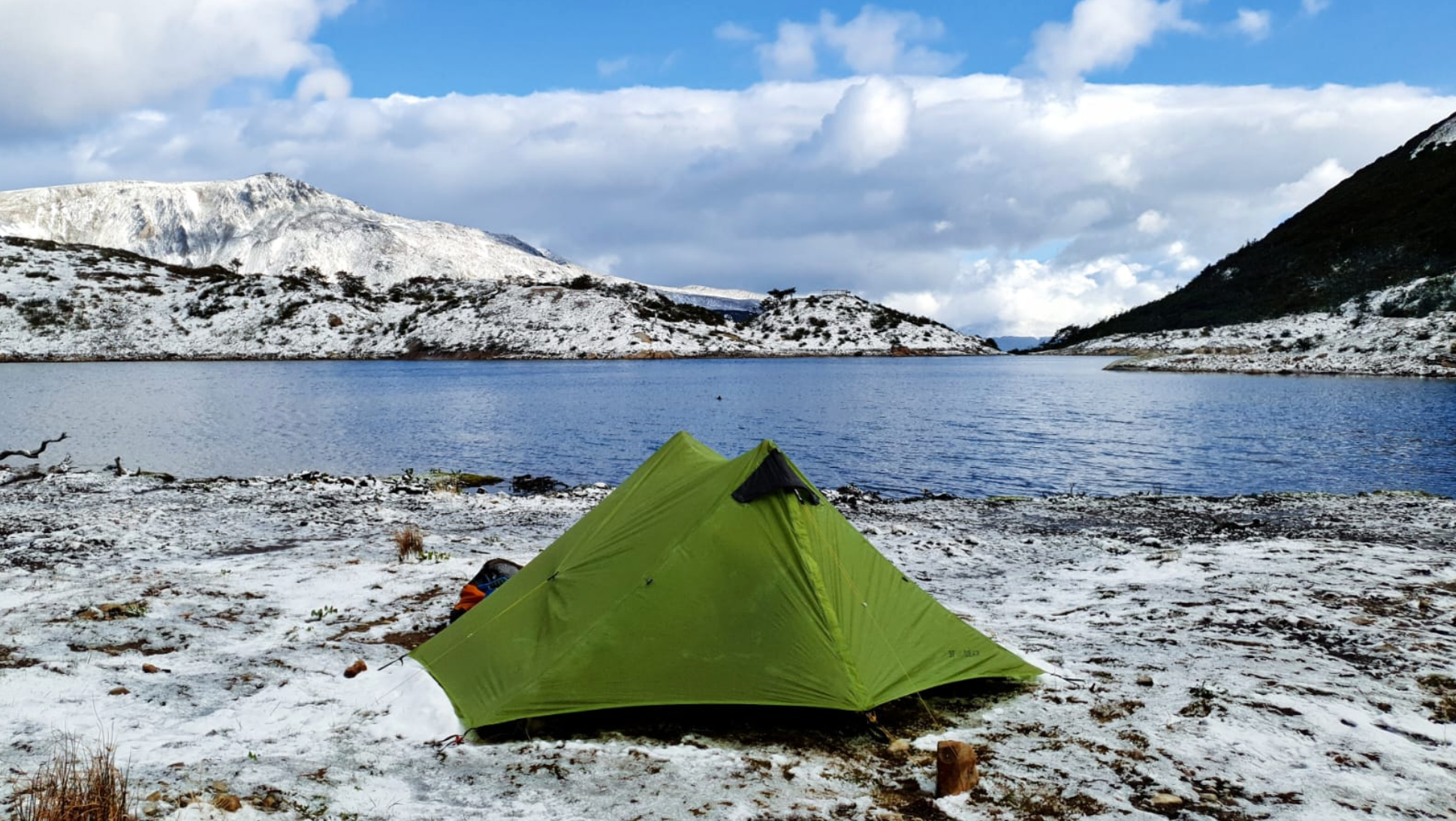Sunny and snowy tent along lake