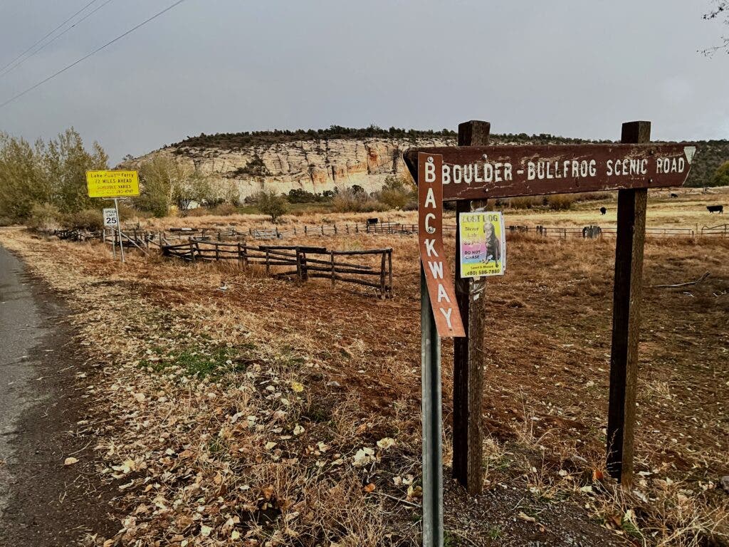 a dirt road and a sign