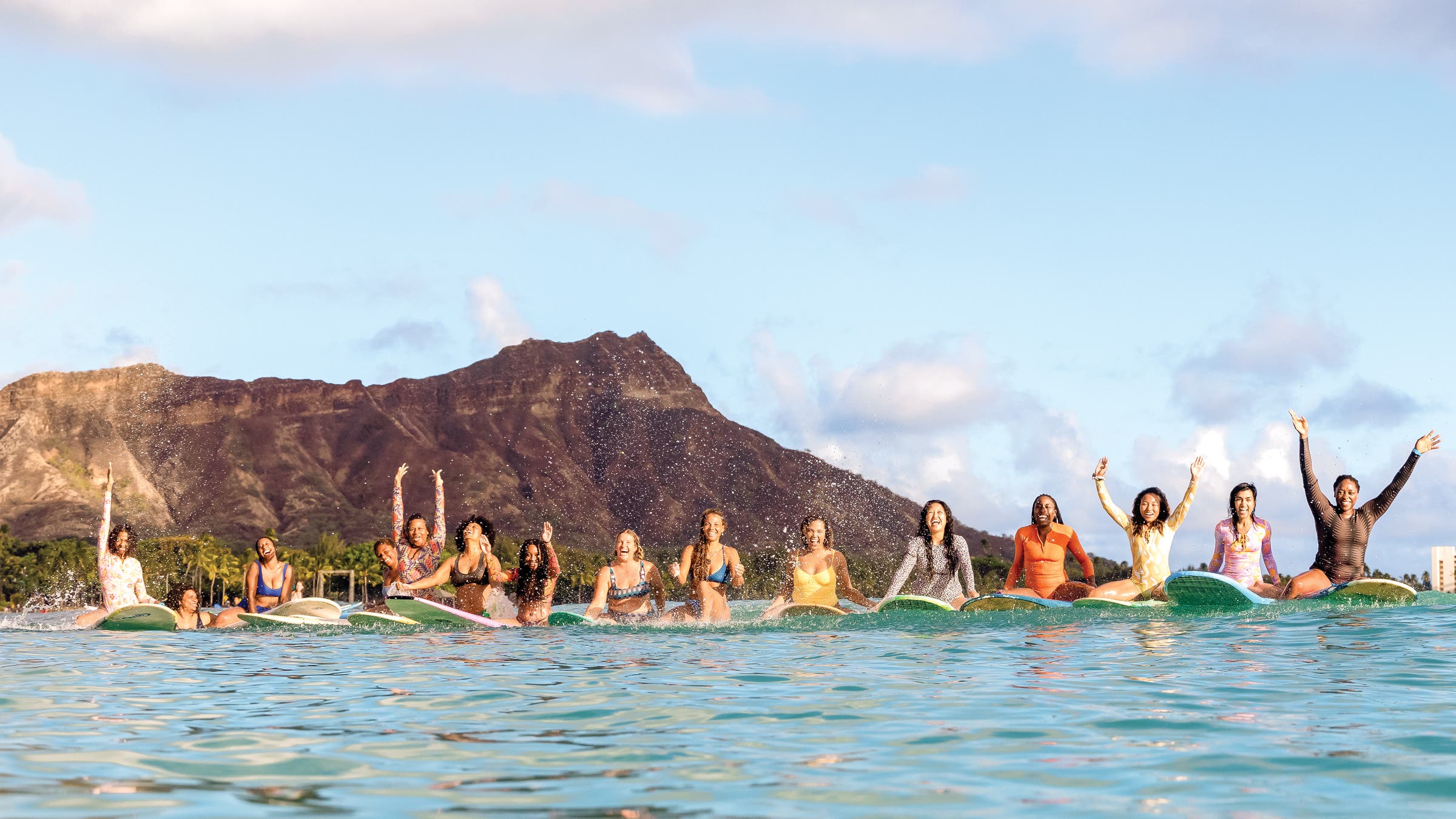 line of women surfers in the water