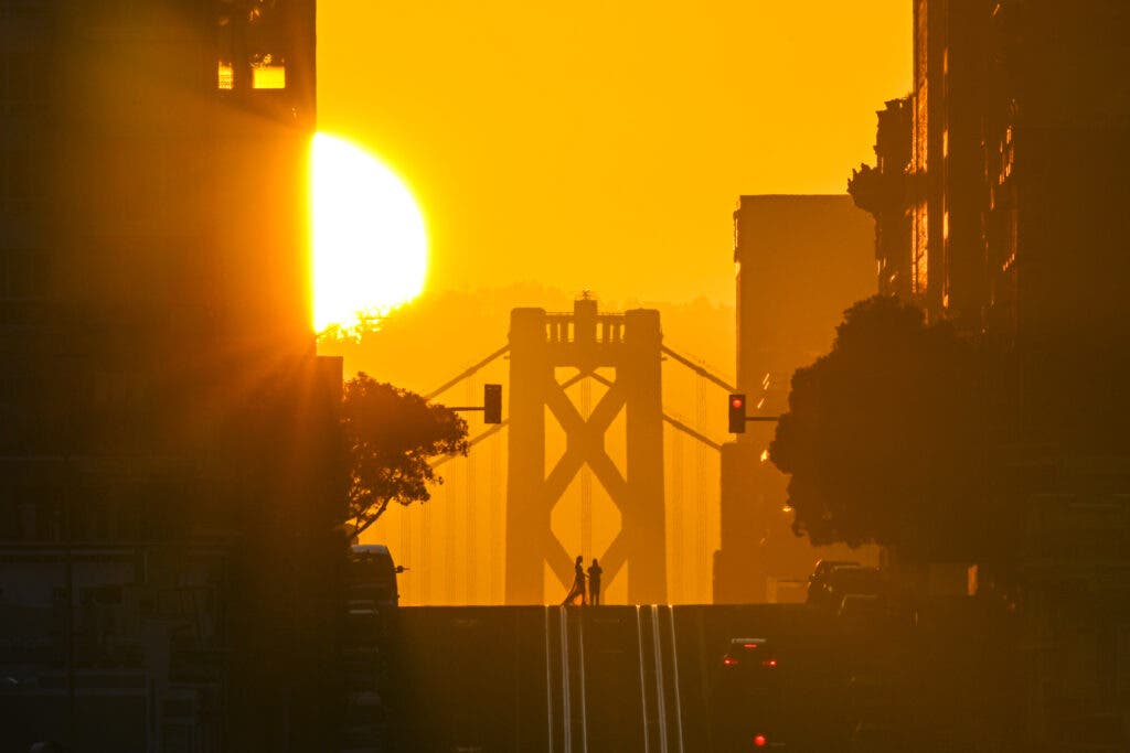 SAN FRANCISCO, CA - APRIL 9: Sun rises over the Bay Bridge and California Street as called 'California Henge' in San Francisco, California, United States on April 9, 2024. (Photo by Tayfun Coskun/Anadolu via Getty Images)