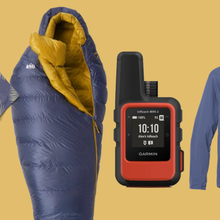 Closeup of men's shirt, sleeping bag, Garmin satellite messenger, and hoody on colorful background