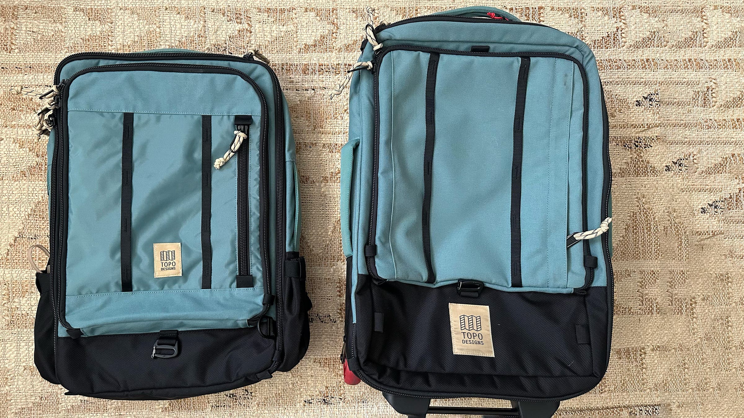 Blue Topo Designs backpack and carry-on luggage on textured carpet