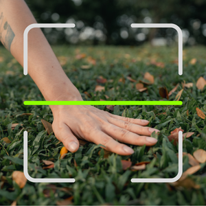 woman's hand on grass touching the grass to get outside