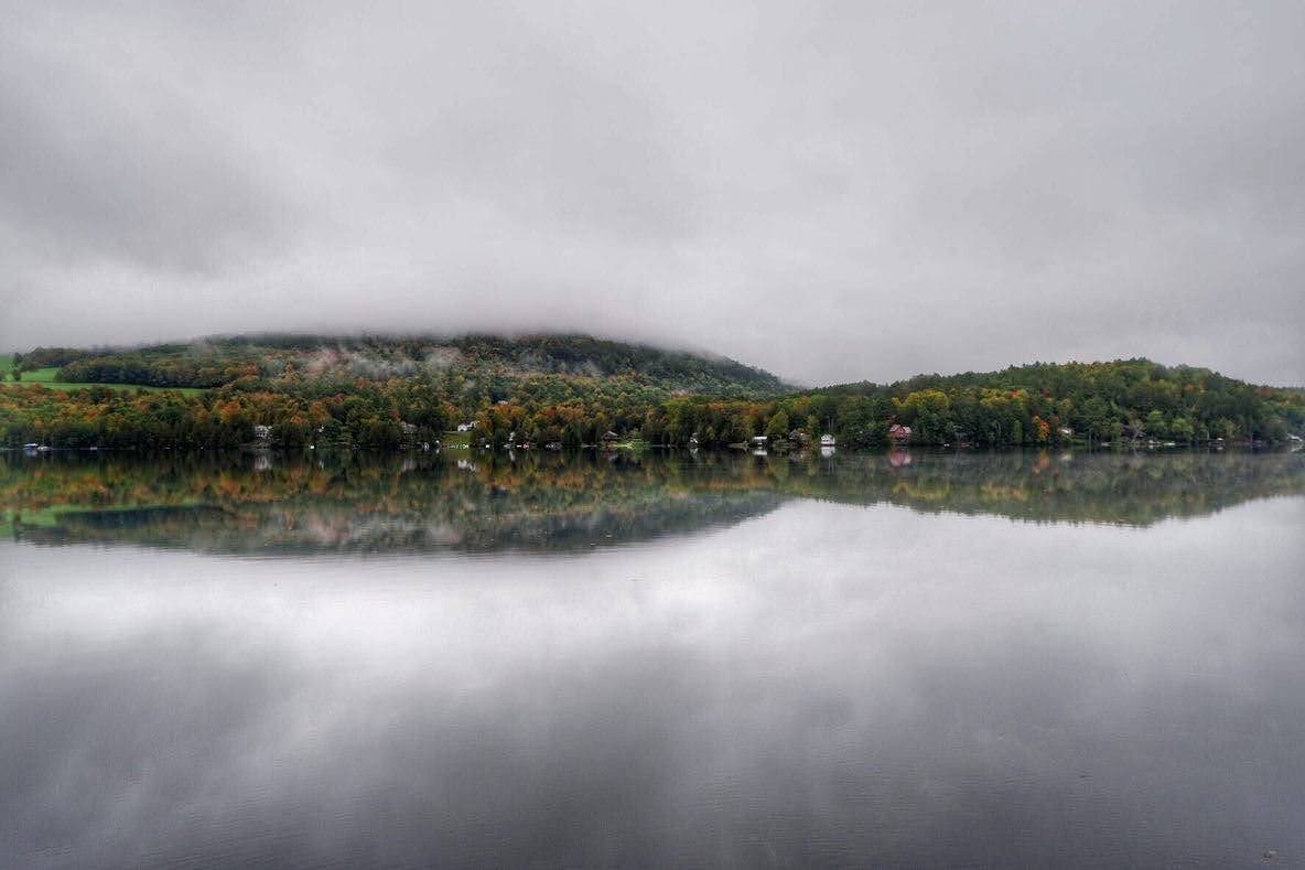 A cloudy day in northeast Vermont, reflected in a lake