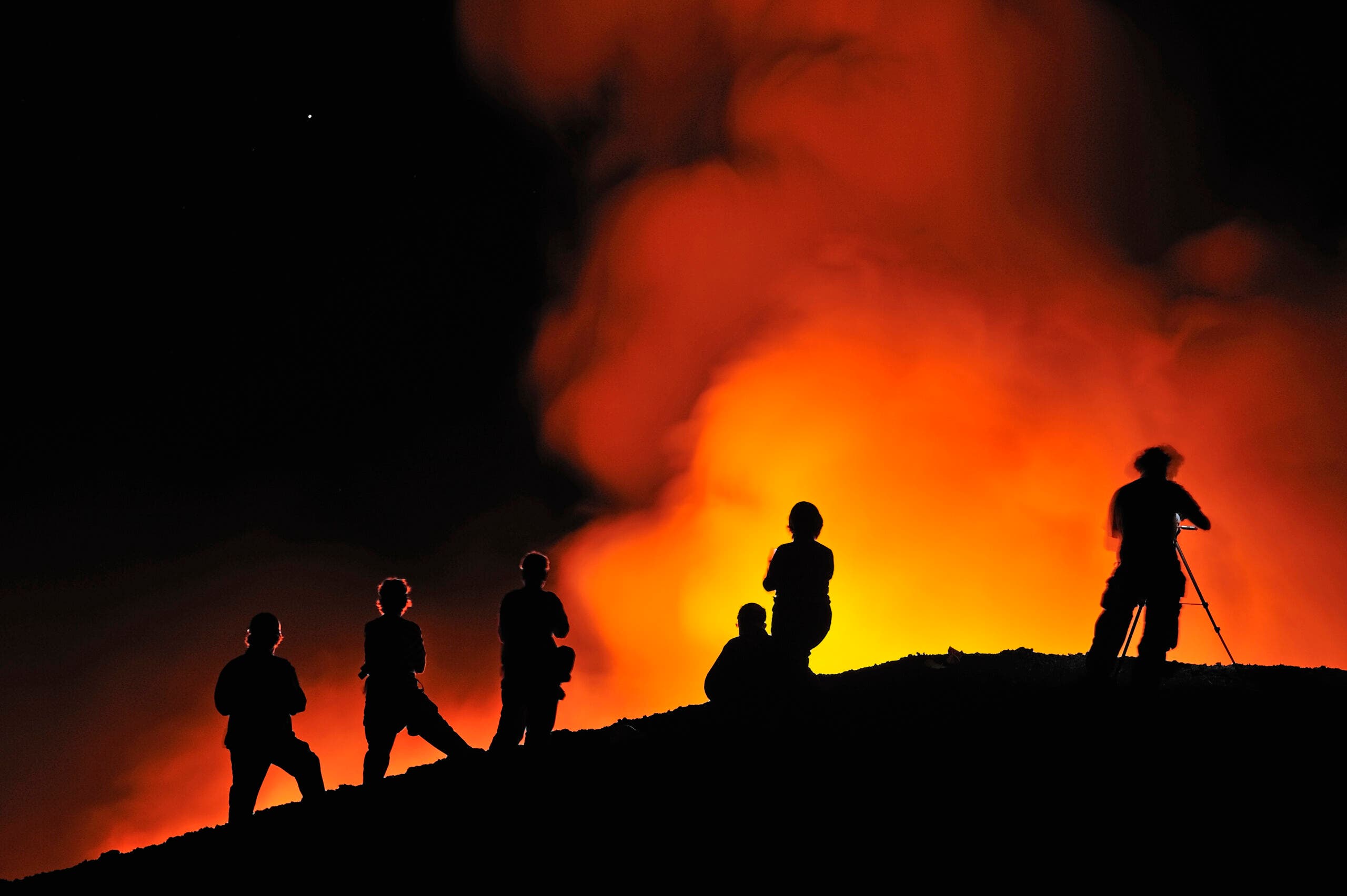 People watching lava flowing to the sea from Kilauea Volcano, Big Island, Hawaii, USA