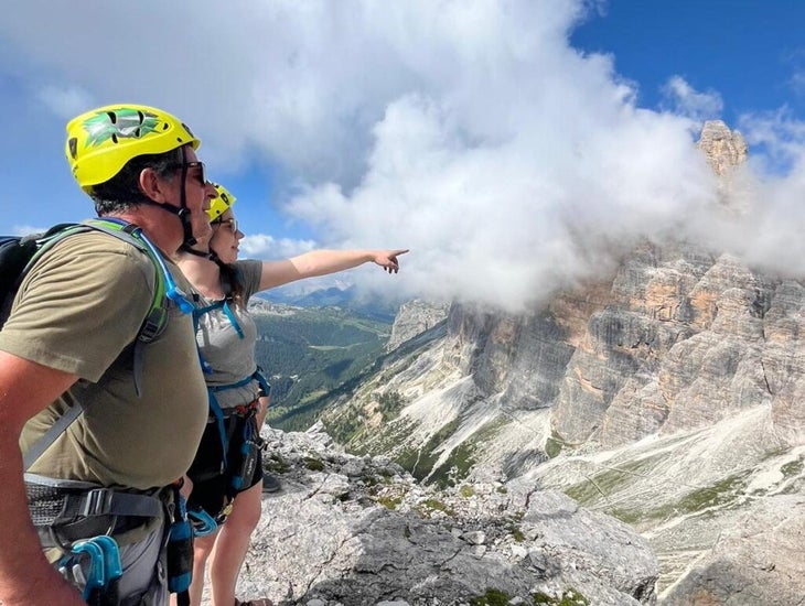 father and daughter stand on a mountain amid the clouds