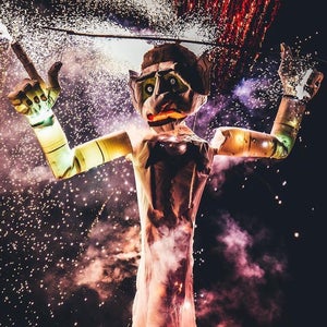 Zozobra, a giant puppet-like structure, burns while fireworks go off in the background