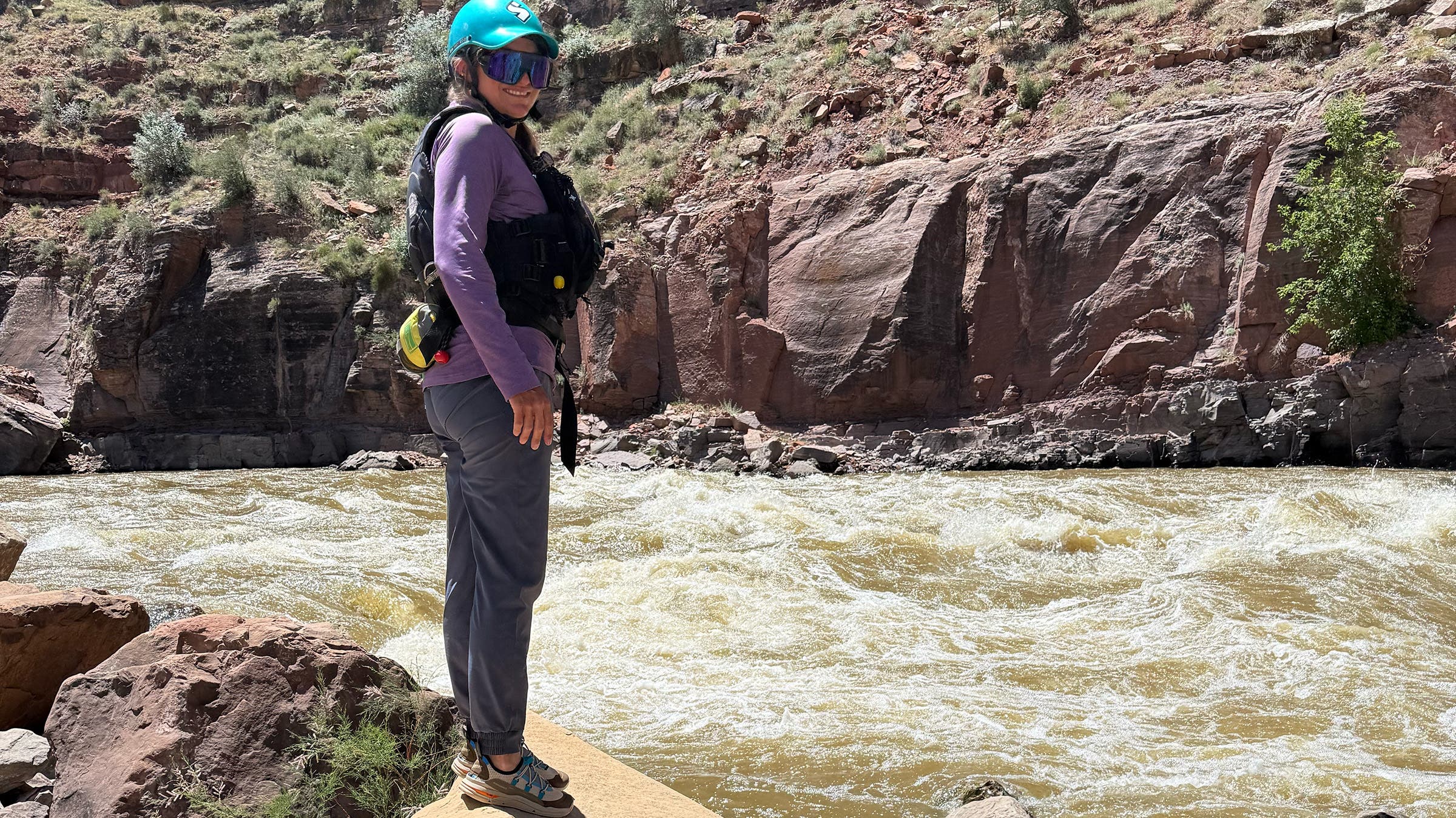 Woman raft guide standing on edge of raging river