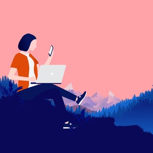 woman doing work with computer outside in mountains