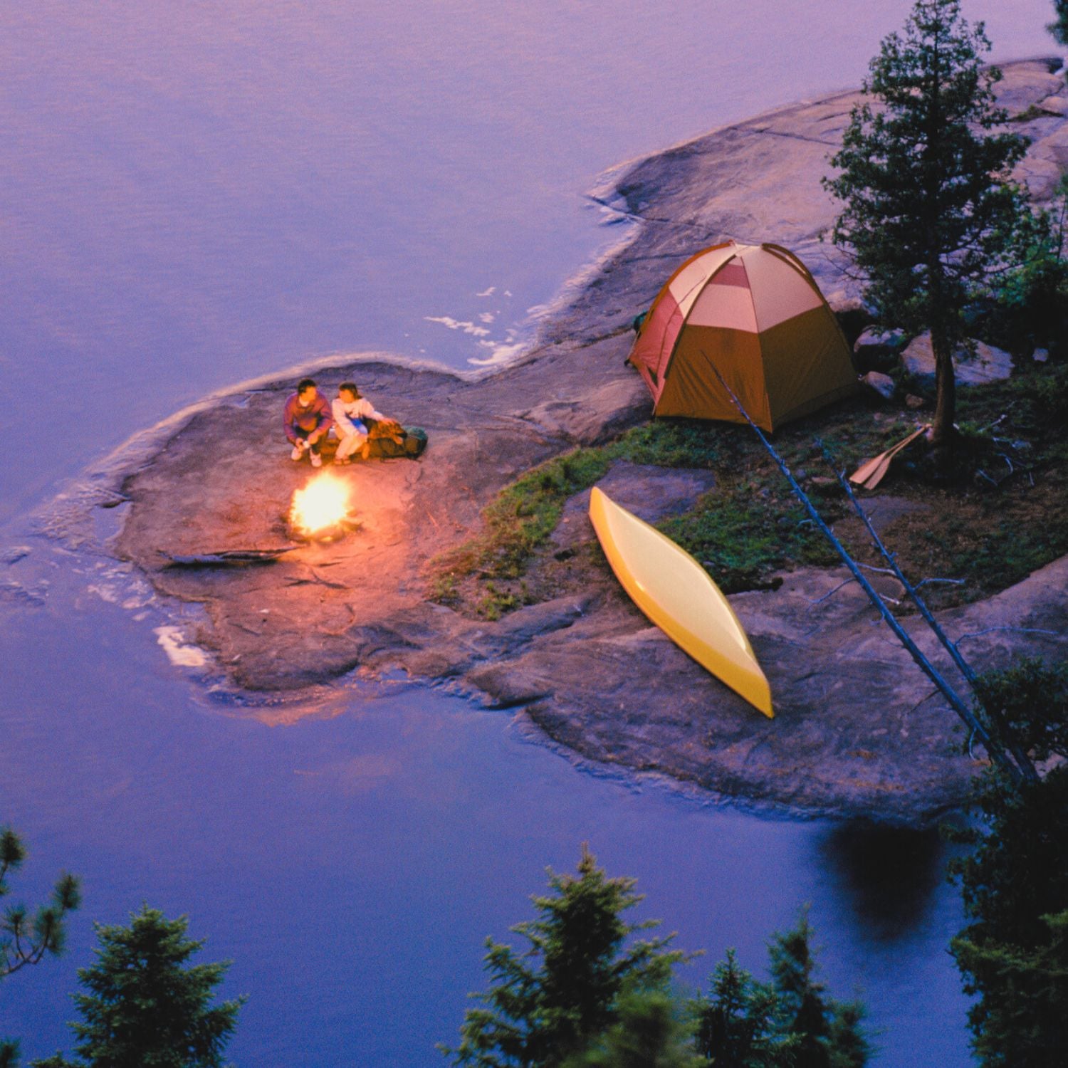 two campers by tent on island