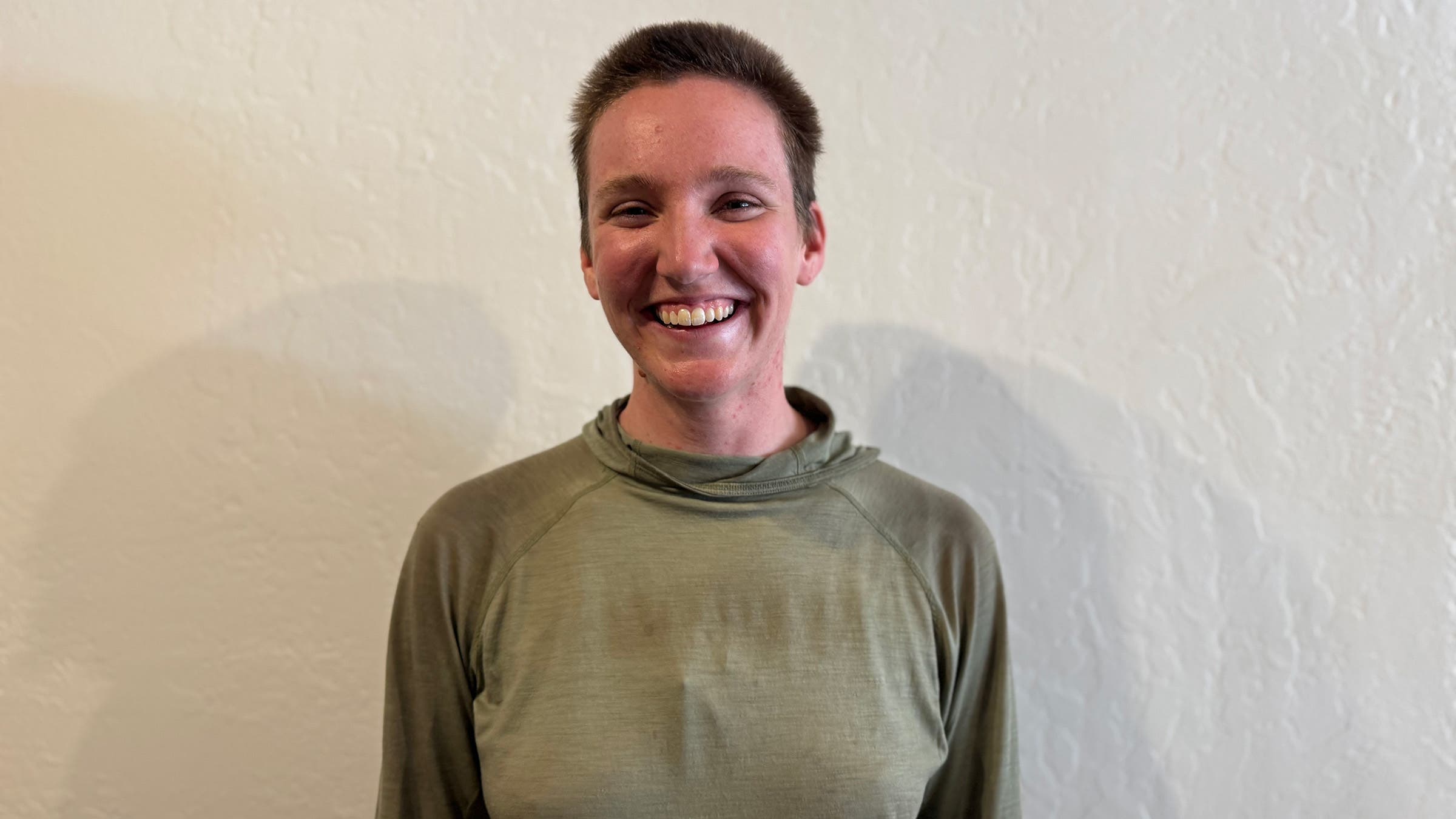 Headshot of woman PCT hiker posing in front of white wall