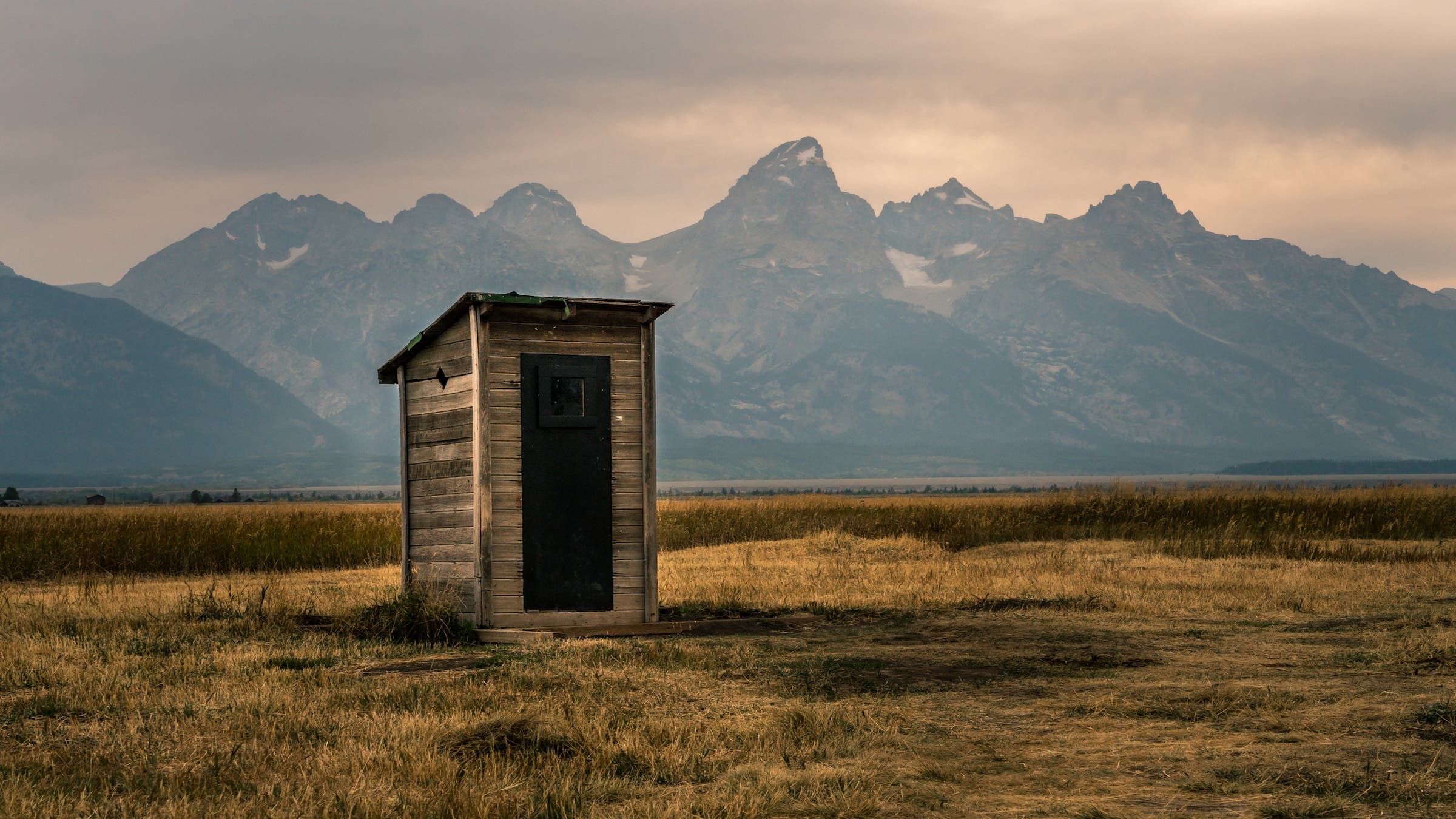 Outhouse in front of the Grand Tetons.