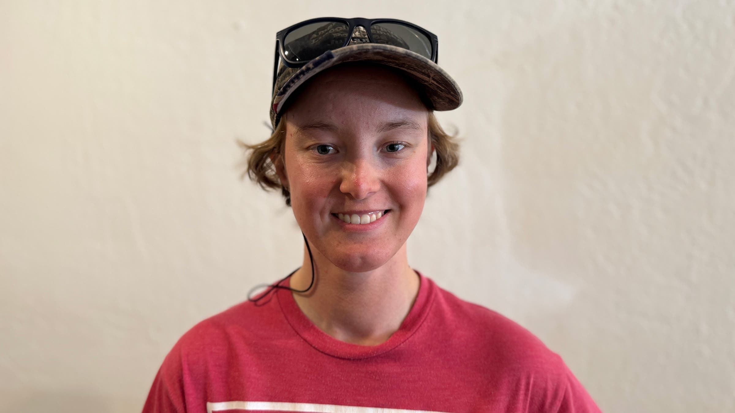 Female PCT Hiker posing in front of while wall