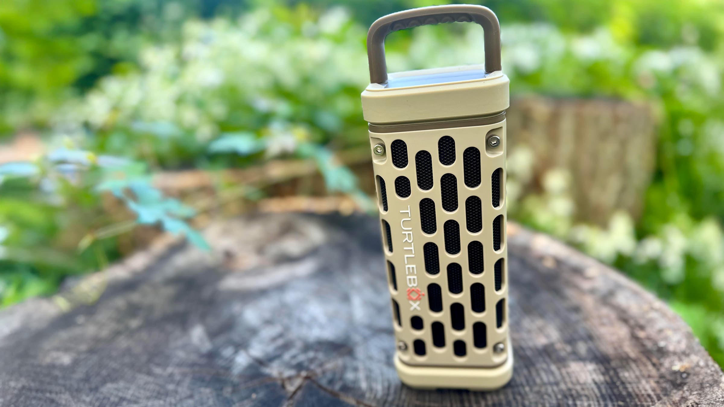 Closeup of Turtlebox portable speaker on tree stump outdoors