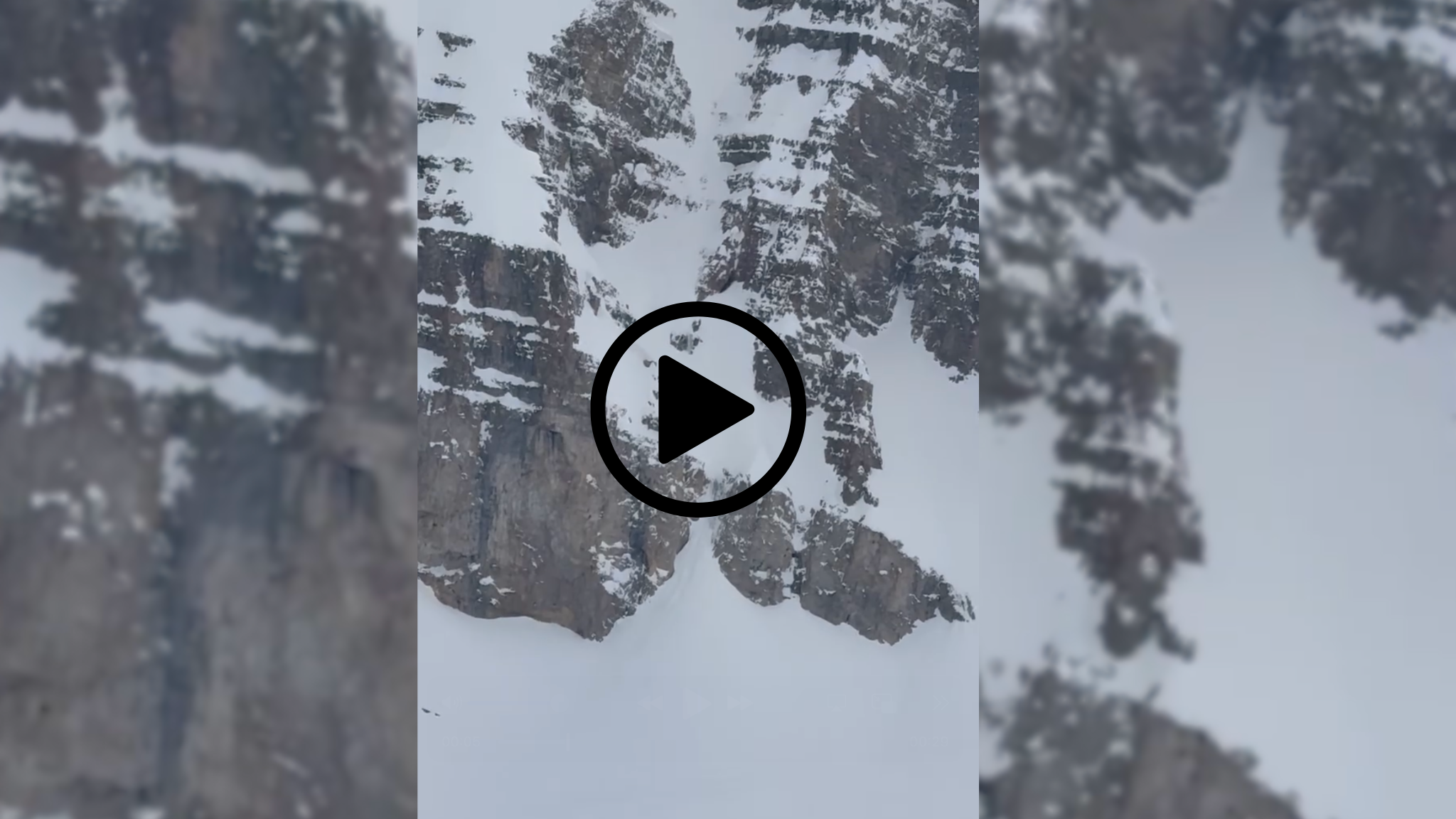 skier falling down with play button overlay.