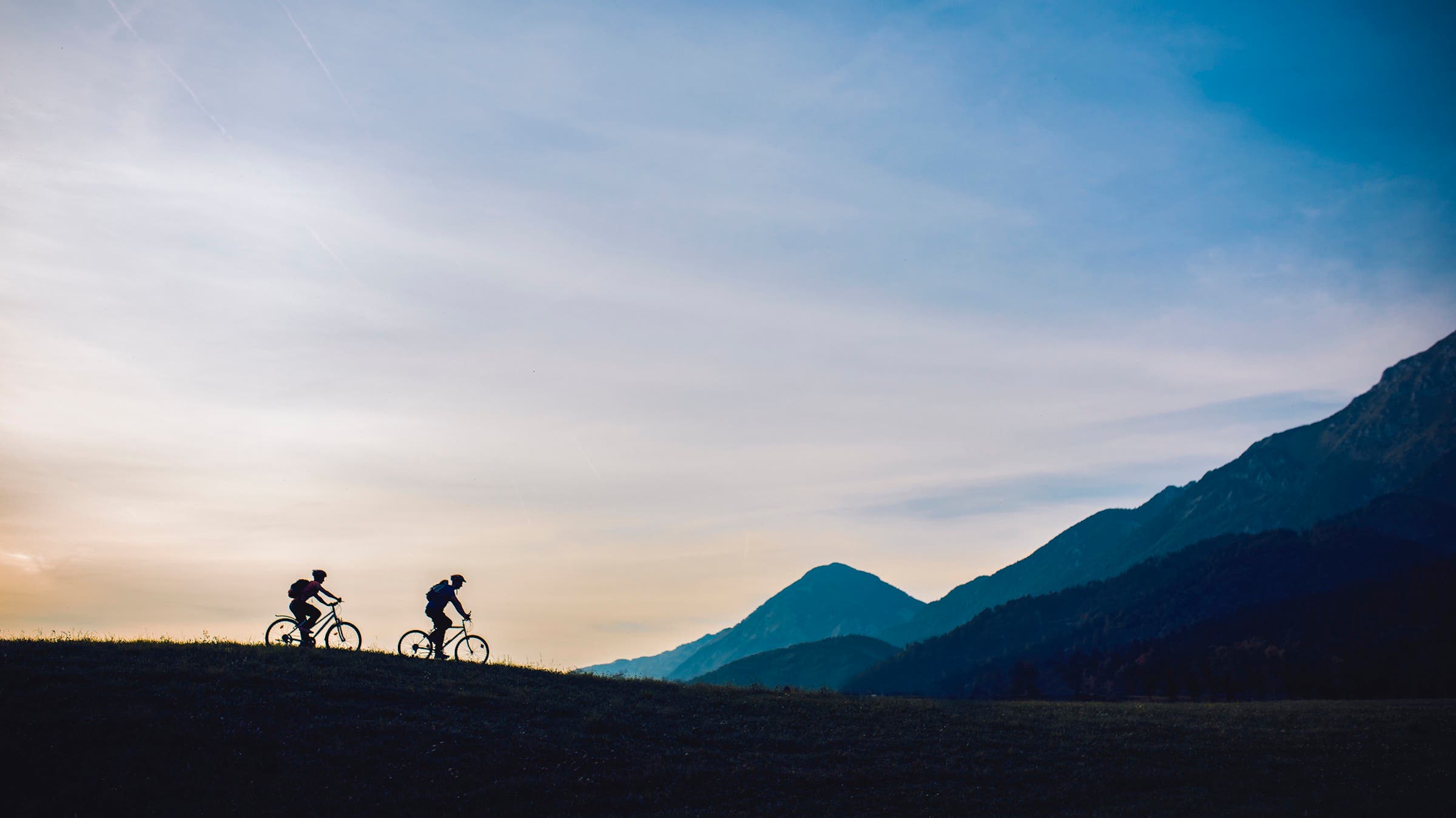 two cyclists biking easily in mountains