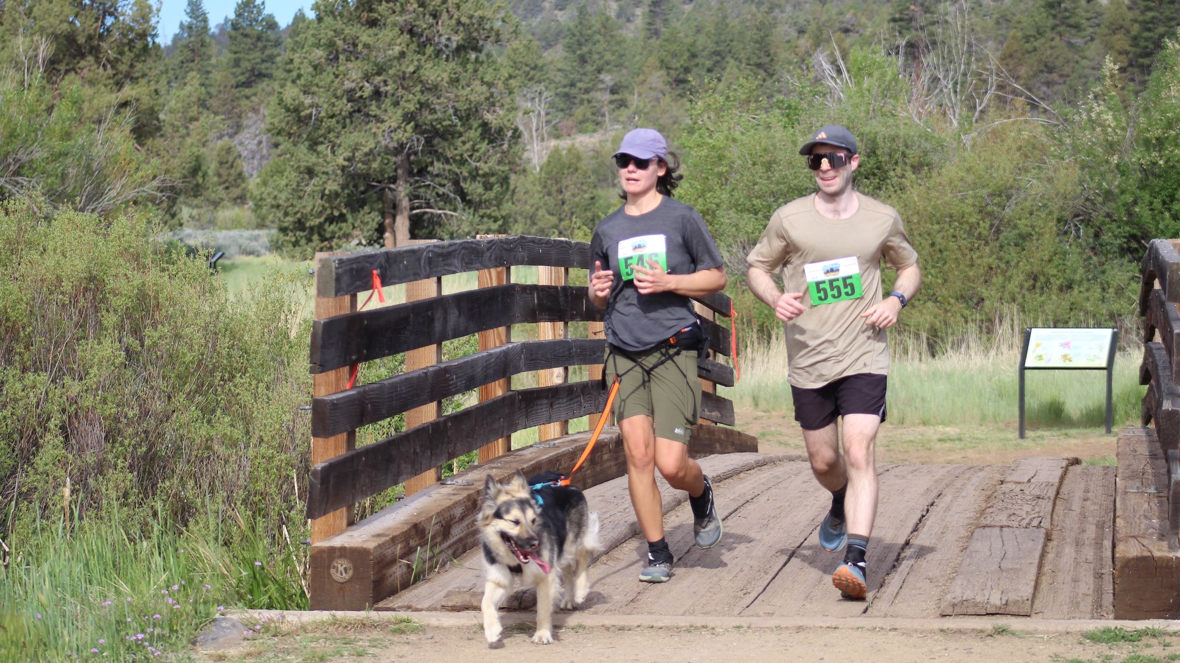 two people running with a dog