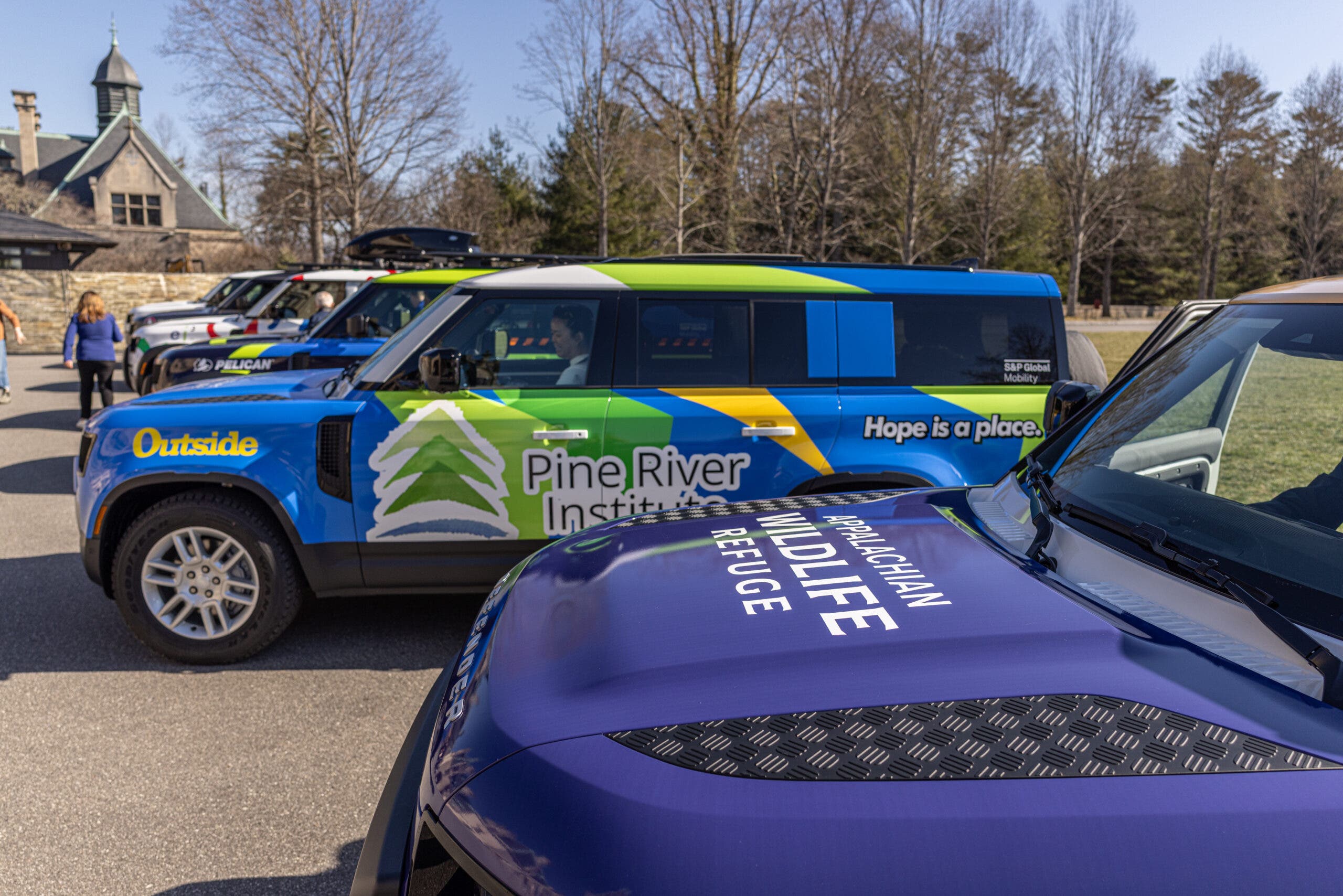 Winners of the 2024 Defender Service Awards receiving their customized Defender 130 vehicles.