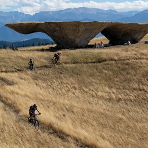 mountain bikers going past an art installation