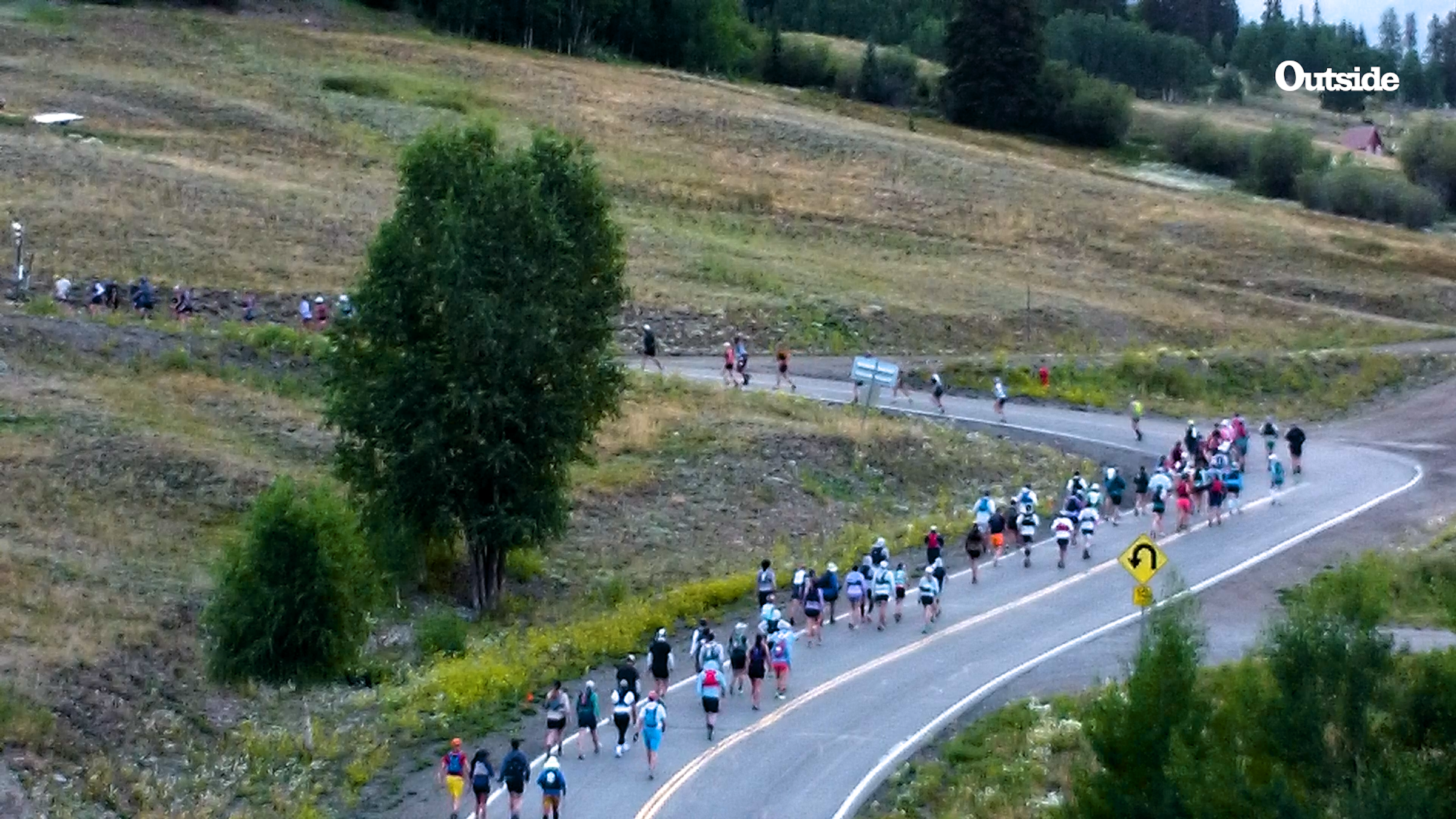 distance shot of runners running up steep road