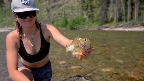 woman holding a golden fish