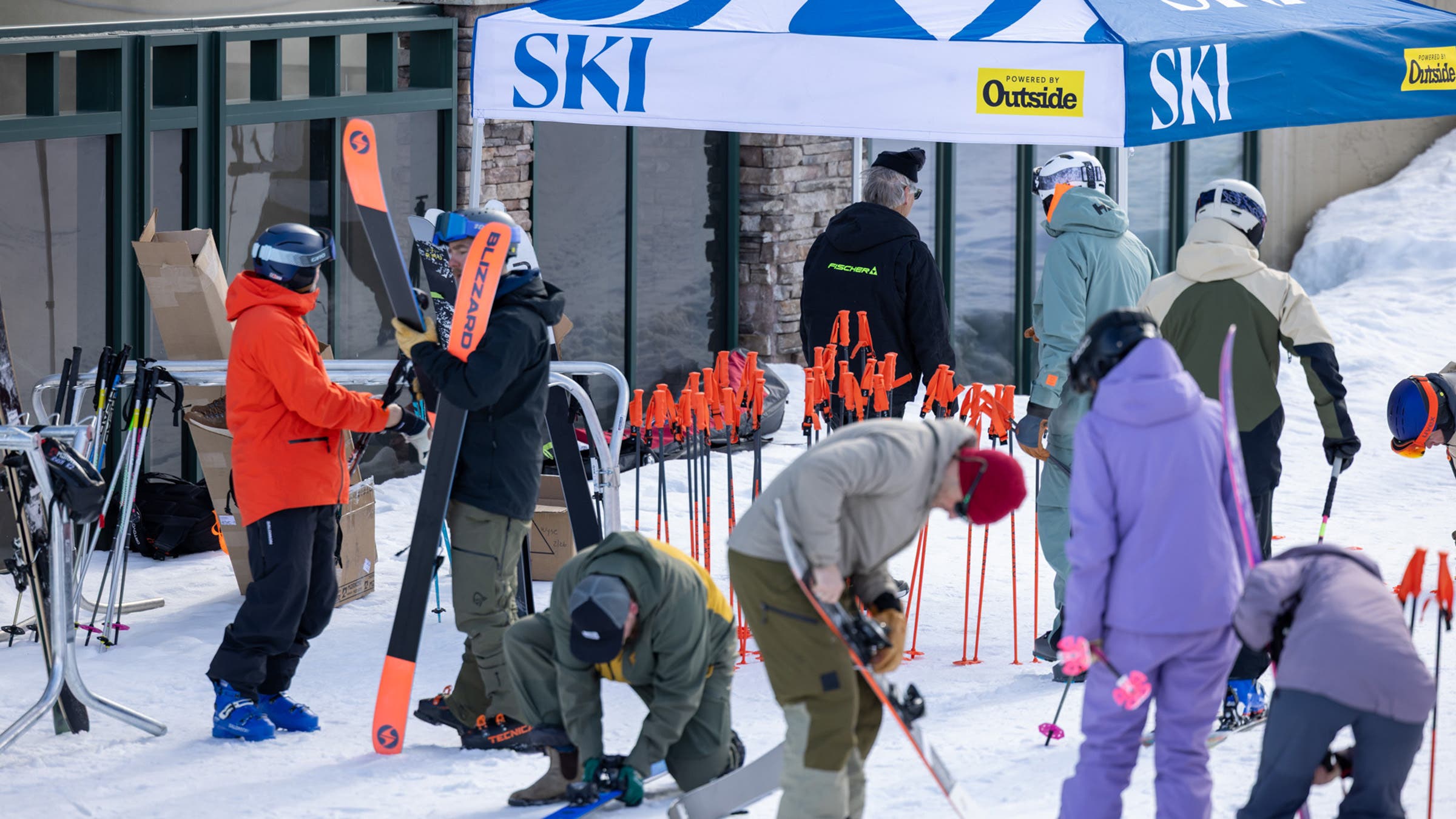 Skiers adjusting all-mountain skis at base area of 2025 SKI Test at Big Sky