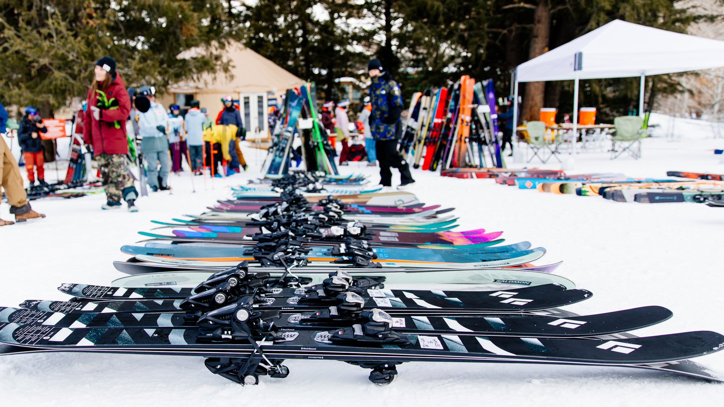 Many pairs of all-mountain skis laid out on snow at annual Outside/SKI Test