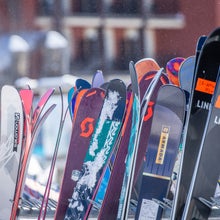 Many pairs of all-mountain skis laid out on snow at annual Outside/SKI Test