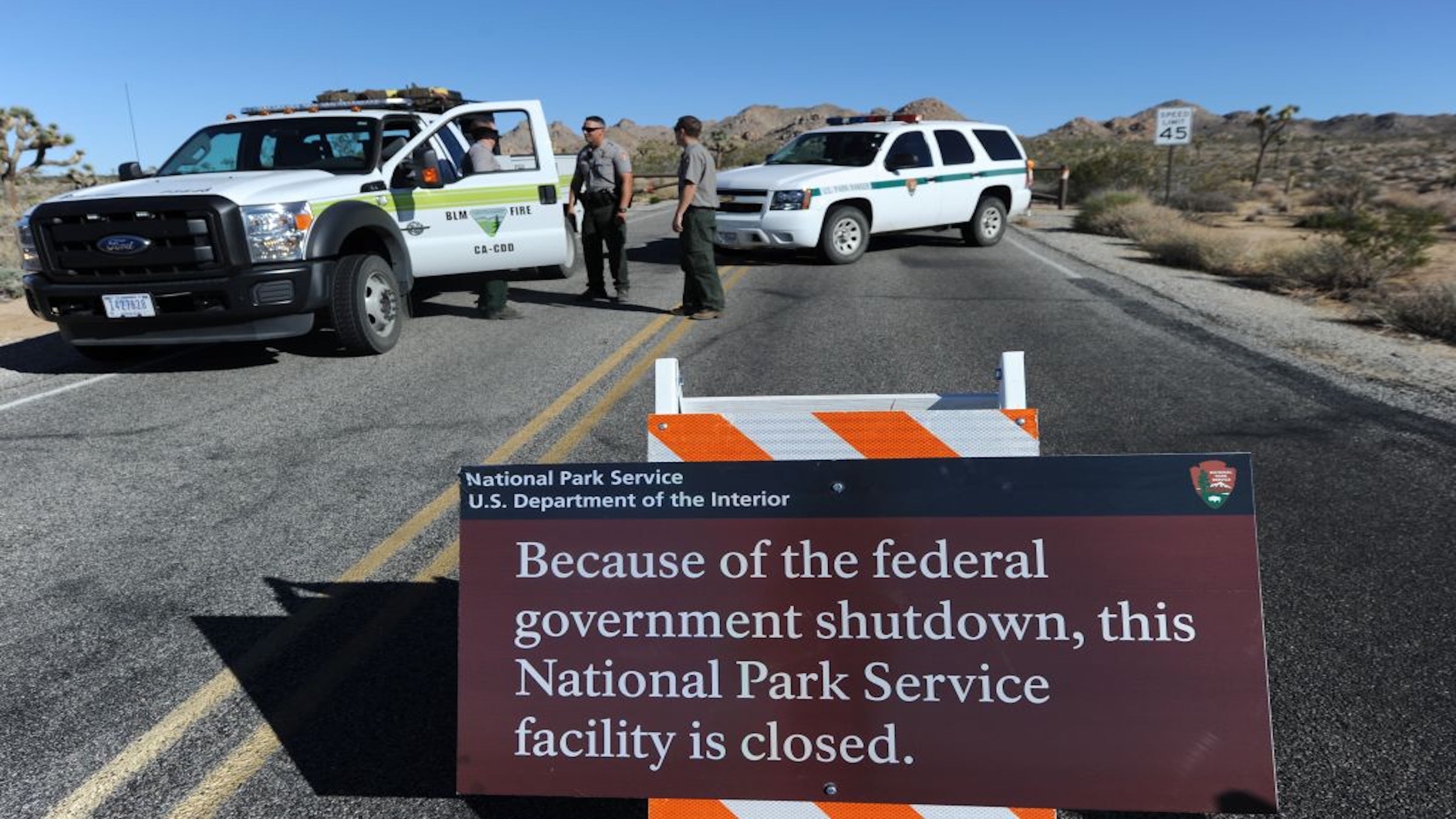 Park Rangers stand at the closed gate to Joshua Tree National Park, in Joshua Tree, California, during the 2013 government shutdown