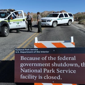 Park Rangers stand at the closed gate to Joshua Tree National Park, in Joshua Tree, California, during the 2013 government shutdown