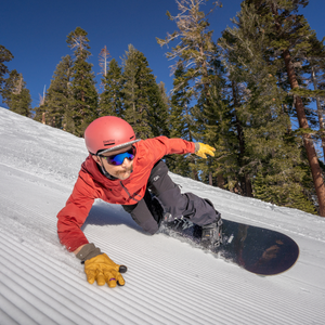 snowboarder leans into turn on corduroy